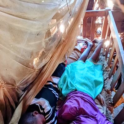 2 Grundschulkinder in einem Babybett